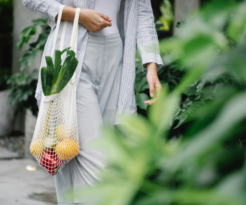 silhouette of a woman holding a bag in her hand with vegetables
